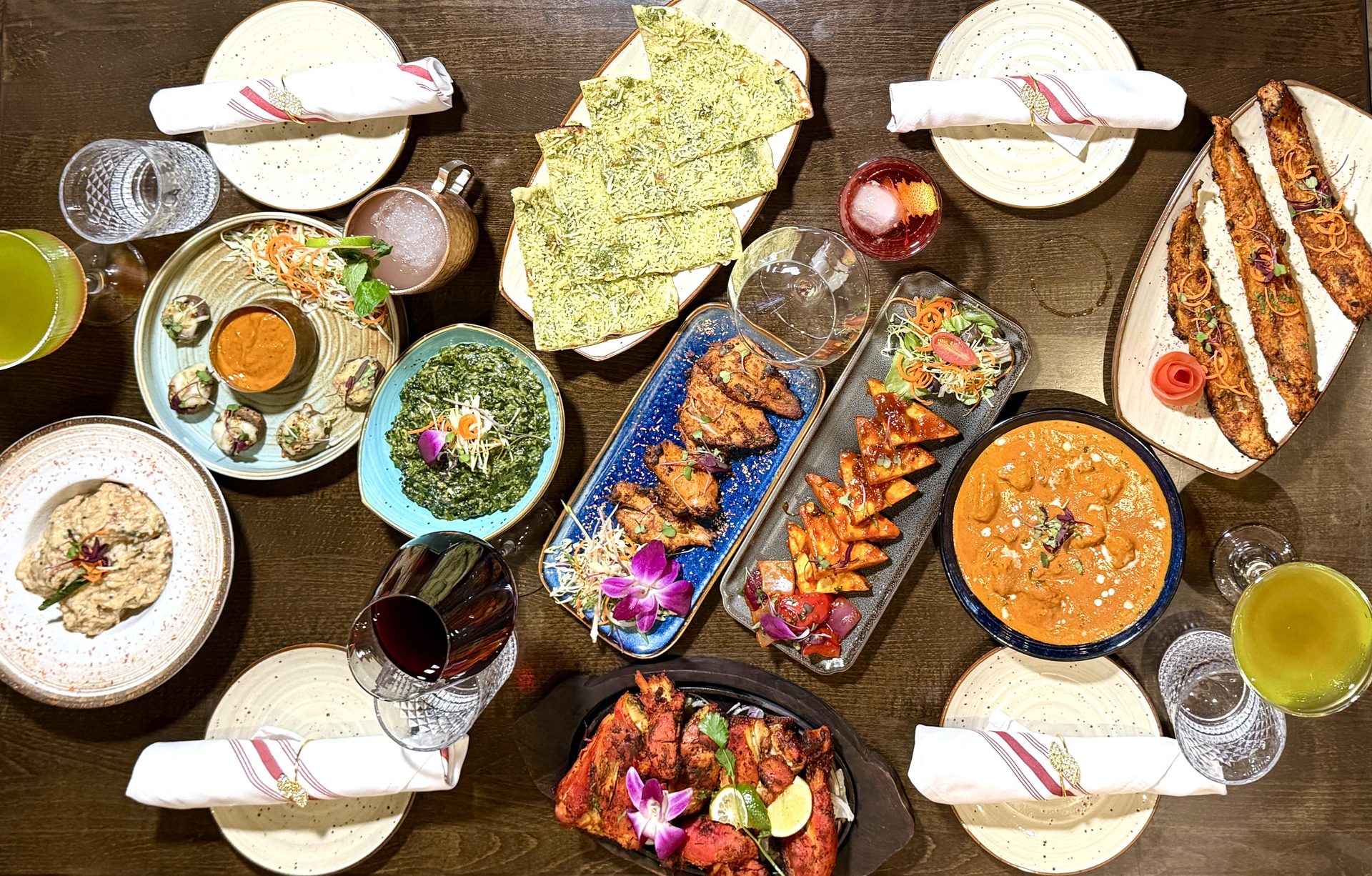 Overhead spread of Ambrosia's Indian dishes and cocktails